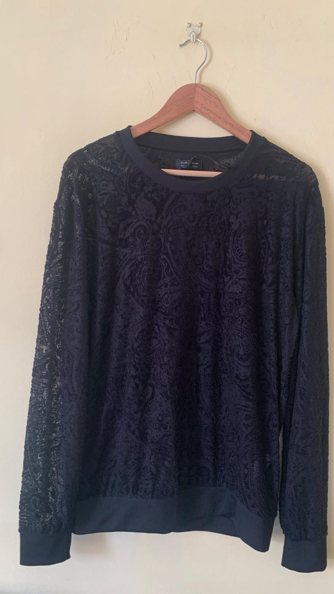 Front view of black sweatshirt with ornamental print and crew neck.