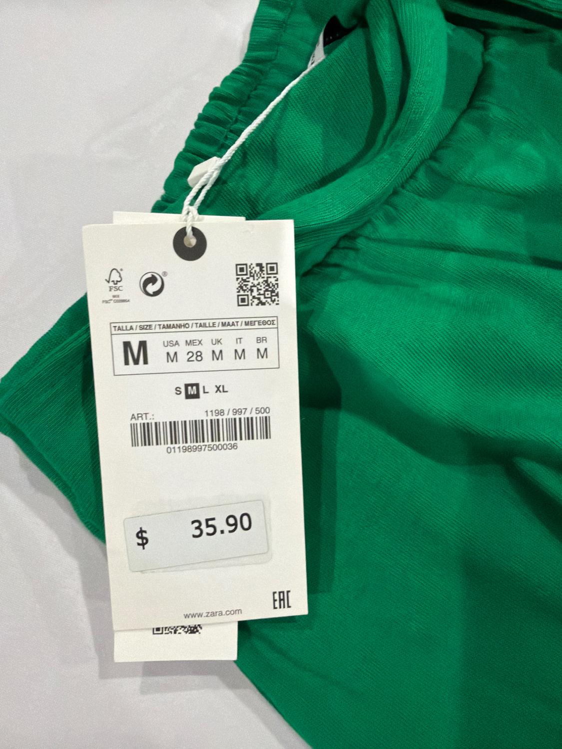 Green garment detail with elasticated waist and label. Text: M USA M MEX 28 UK M IT M BR M S M L XL ART.: 1198/997/500 $ 35.90