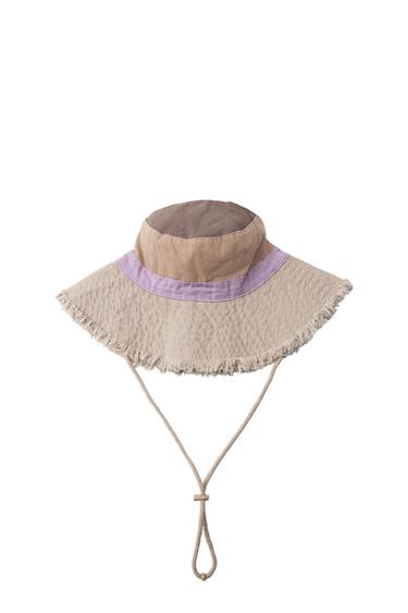 Colour-block bucket hat in brown, beige and purple. Wide brim with frayed edges and an adjustable drawstring on a white background.
