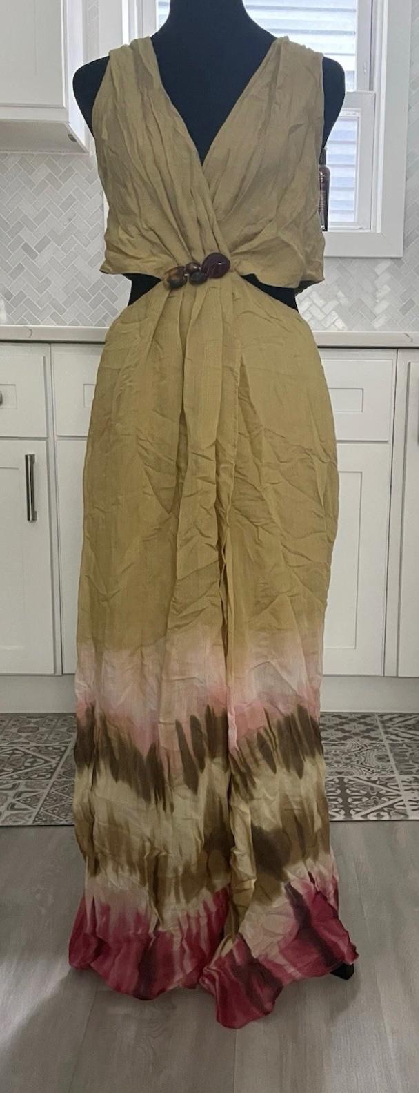 Sleeveless maxi dress in beige tones with a pink and brown ombré design, fastened with a jewelled clasp, white kitchen backdrop.