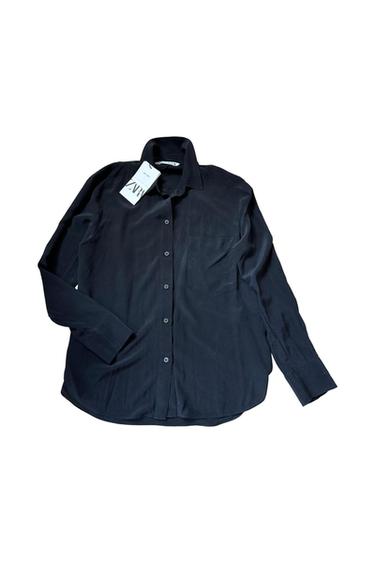 Black long-sleeved shirt with a collar, front buttons and a chest pocket against a white background. Visible label bearing the text ZARA.