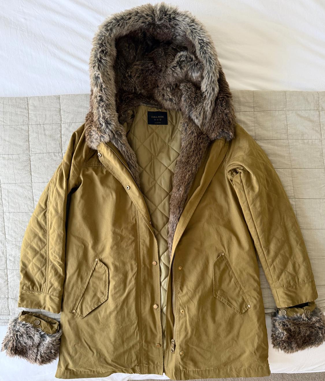 Brown coat with hood and faux fur cuffs, padded lining, on a beige quilt. Label: "ZARA BASIC".