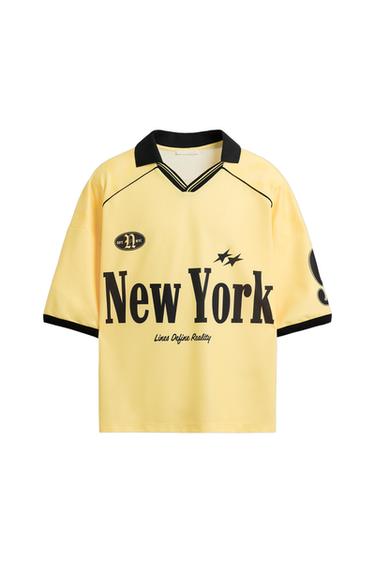 Yellow t-shirt with black collar and trim. Text: "DPT. N NYC", "New York", "Lines Define Reality" and two stars on the chest.
