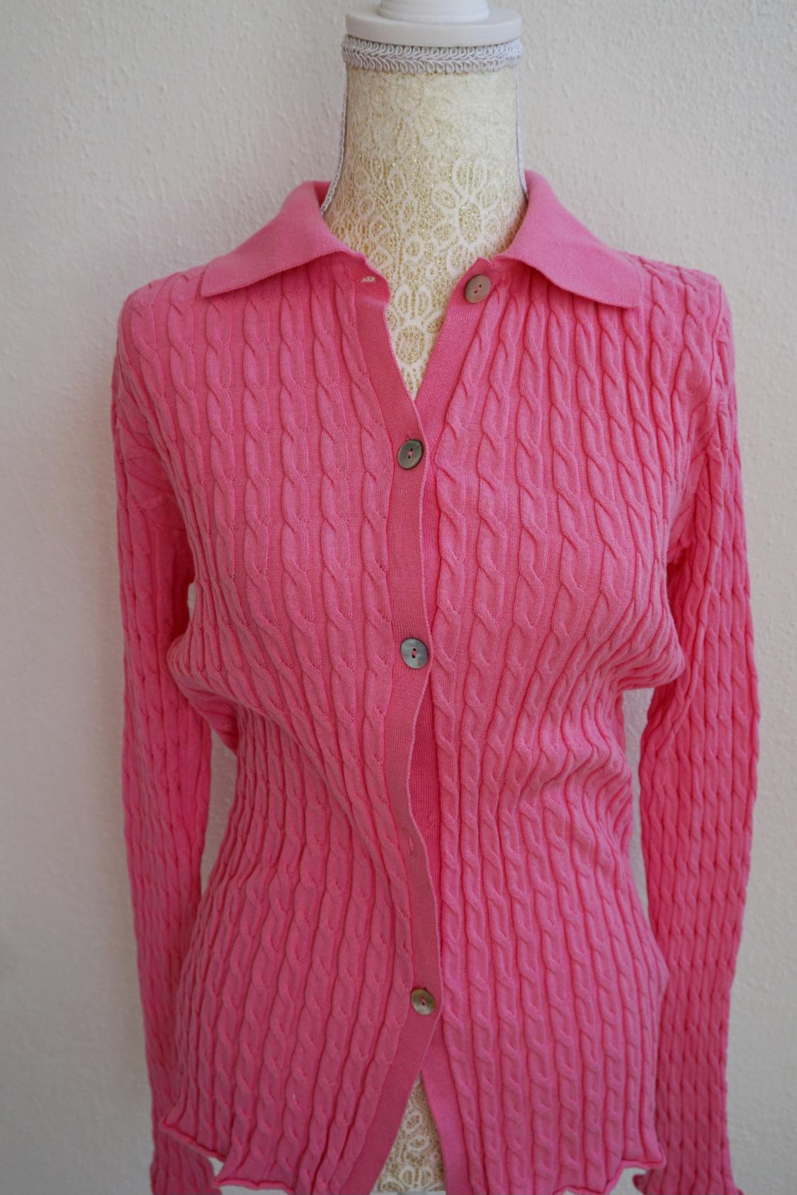 Mannequin in a pink cable knit cardigan with front buttons, on a white background.