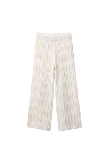 Front view of white knit pants with elastic waistband and braid design.