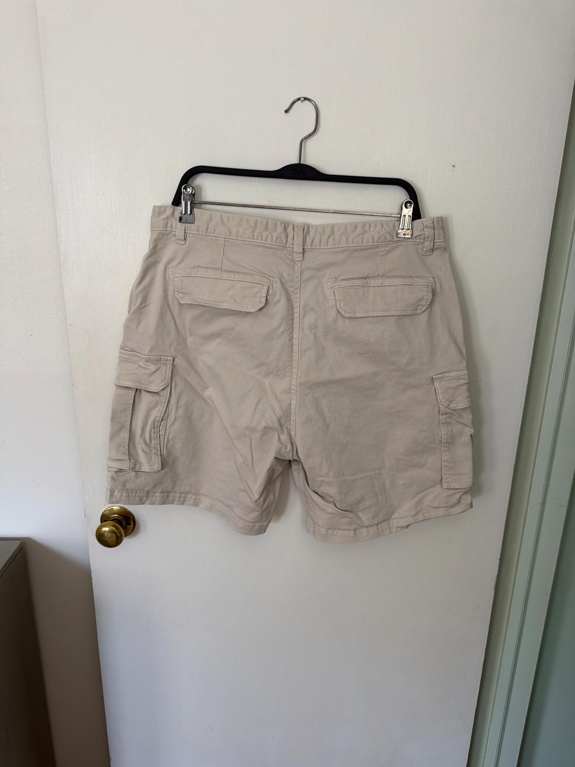 Elastic waistband shorts. Front pockets and back flap pockets. Flap patch pockets at legs. Front zip and button closure. - Image 2