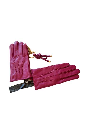 Pink leather gloves with stitching details, accompanied by a gold keyring and visible label with "ZARA" text.