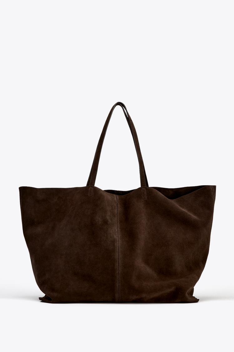 Front view of a large dark brown bag with long handles and visible central stitching.