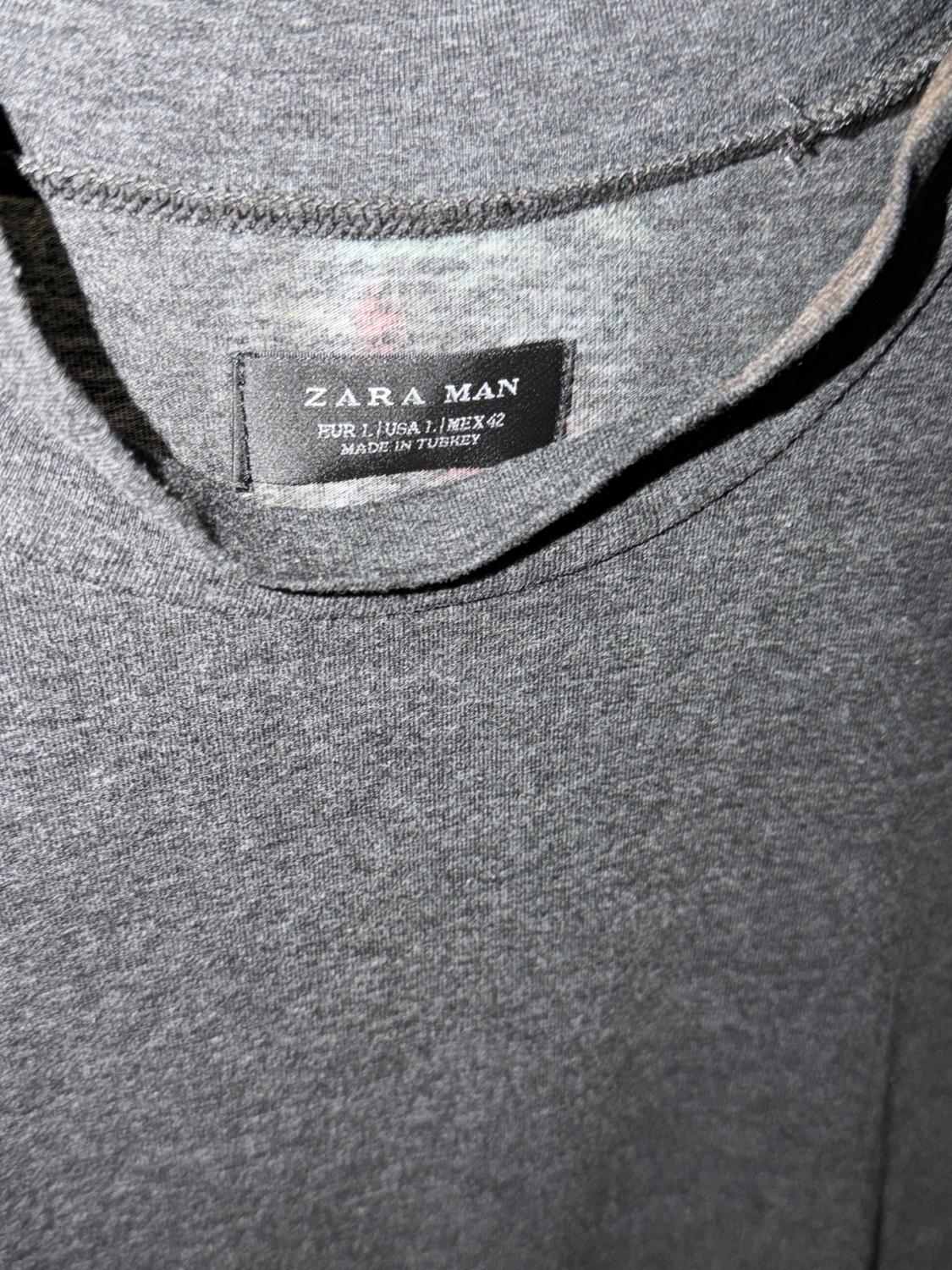 Detail of a gray t-shirt with a label that says: ZARA MAN EUR L / USA L / MEX 42 MADE IN TURKEY.