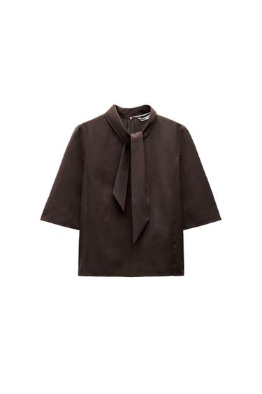 Front view of a brown blouse with a neck tie and short sleeves.