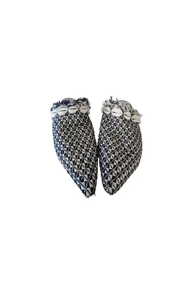 Closed-toe shoes with a black and white geometric print, decorated with shells on the upper edge.