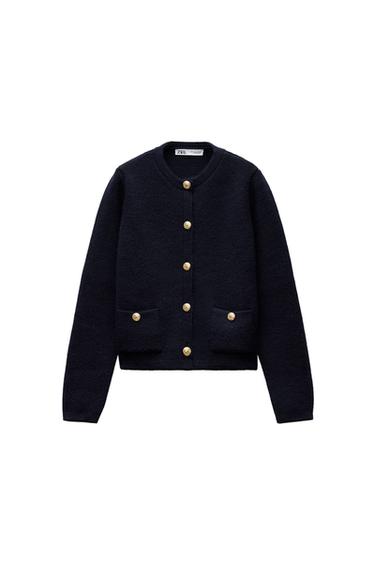 Front view of a black jacket with gold buttons and front pockets.