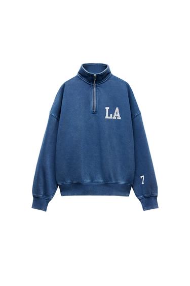 Front view of a blue zip-up sweatshirt with the text 'LA' and '7'.