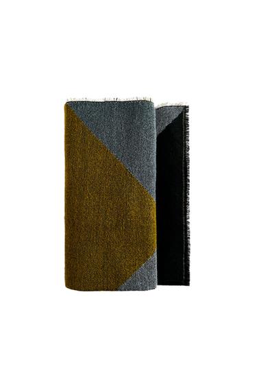 Detail of a scarf with a geometric design in grey and mustard colours.