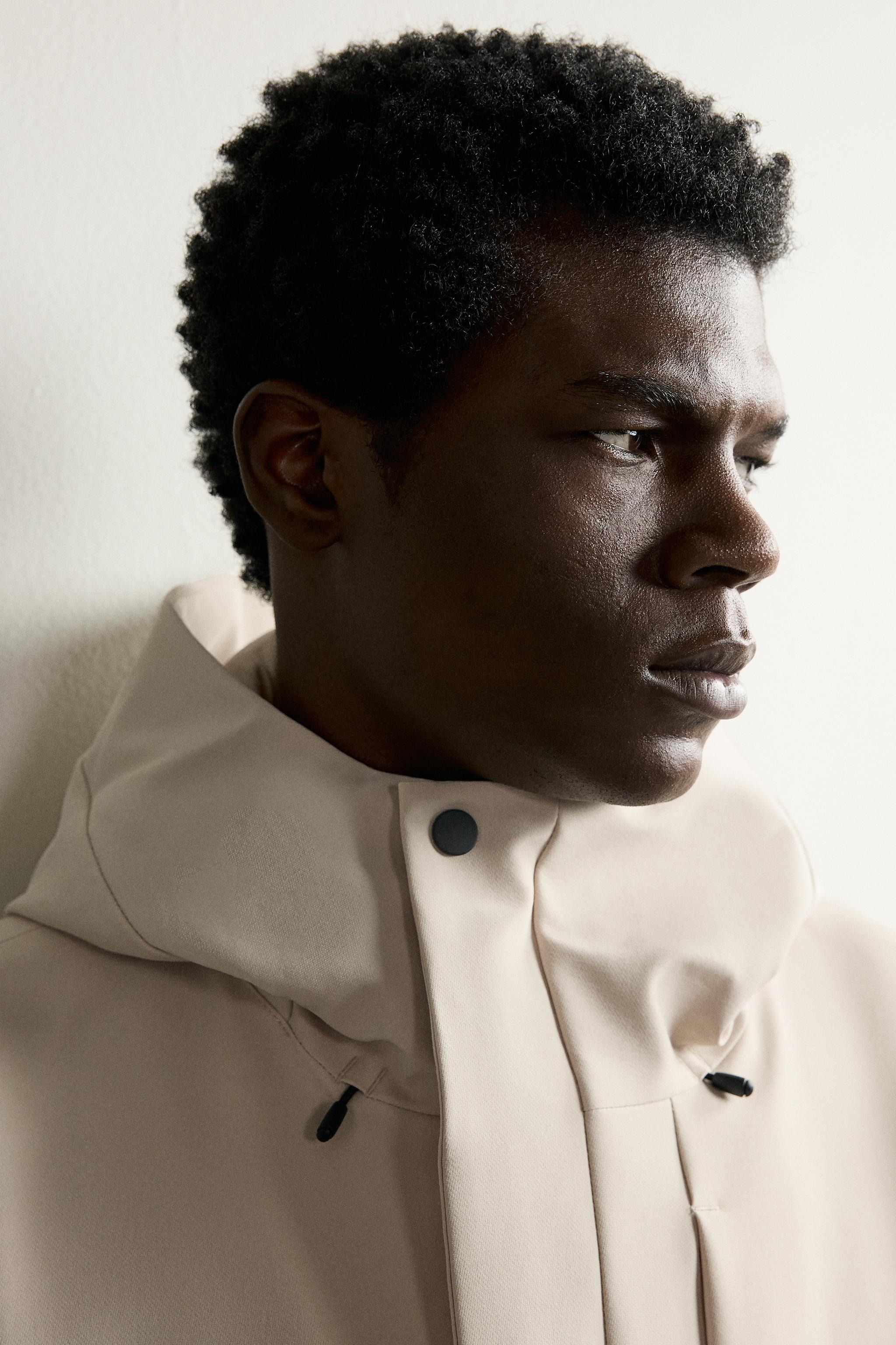 BLOUSON TECHNIQUE À CAPUCHE DÉPERLANT