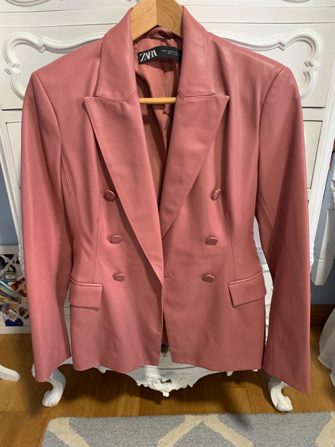 Front view of a pink jacket with wide lapels and double buttons. Visible flap pockets.