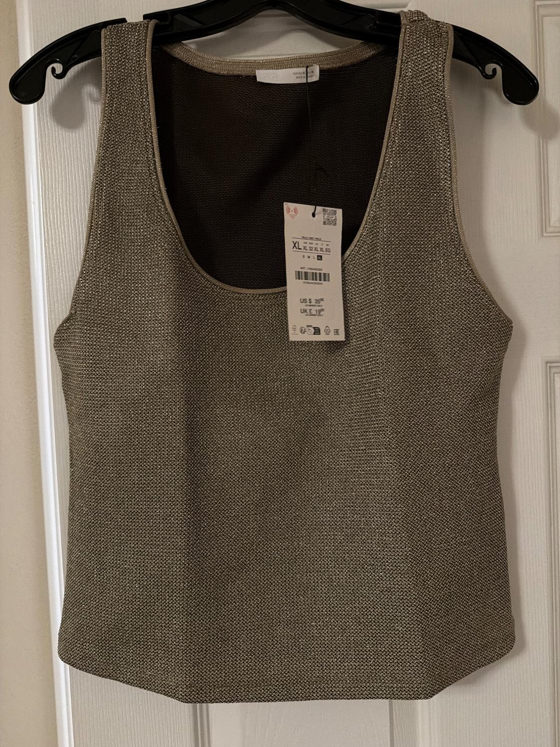 Gold metallic knit sleeveless top on a black hanger over a white door. Text: ZARA XL US $ 35.90 UK £ 19.99.