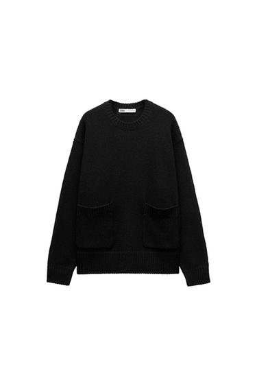 Black chunky knit jumper with a round neck and two front pockets. Visible neck label with "ZARA" text. White background.