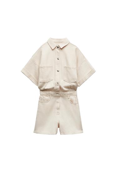 Beige short-sleeved romper with a collar, button closure, and chest and side pockets, against a white background.