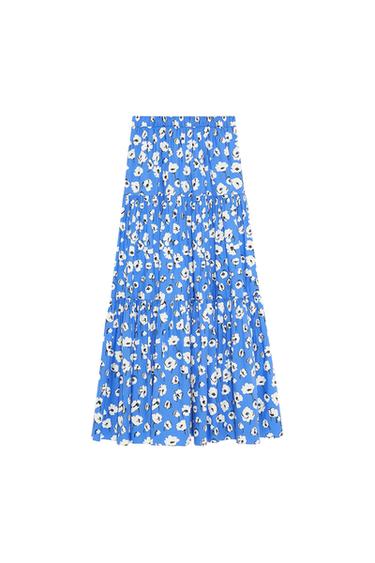 Blue maxi skirt in a fluid style with a tiered design and a white floral print, presented against a white background.