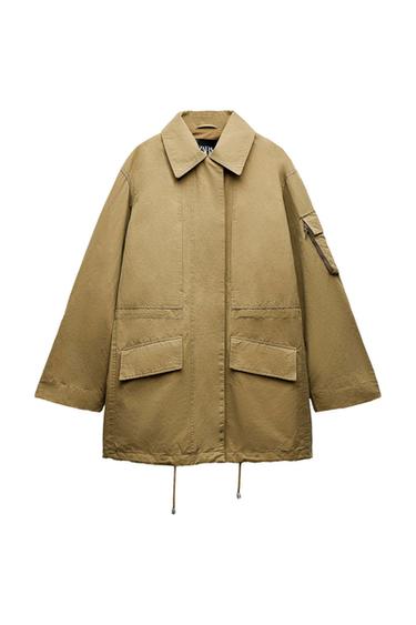 Beige jacket with a classic collar, front and sleeve pockets, and a concealed closure. Visible inner label with "ZARA" text.
