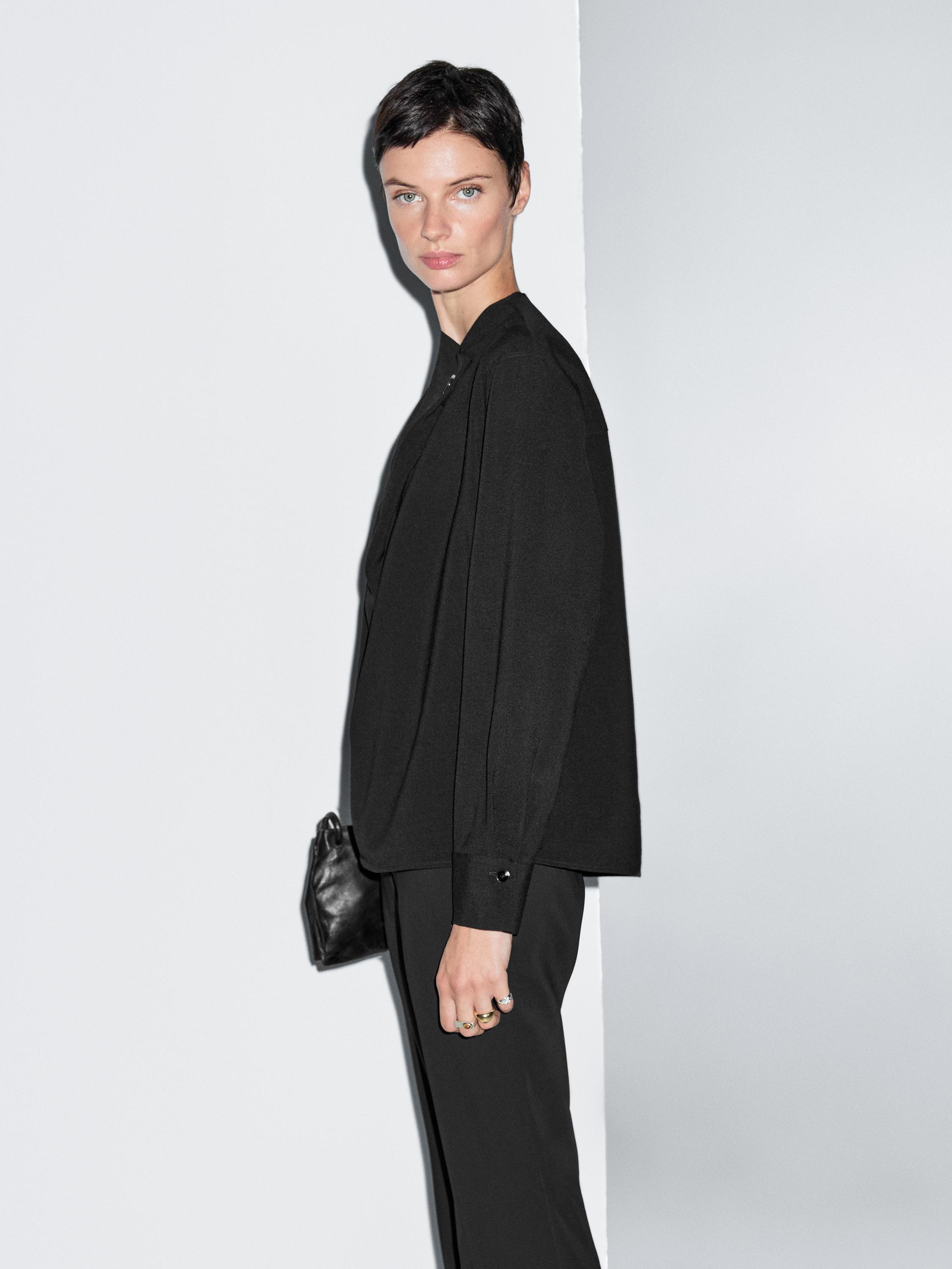 Blouse with crossover detail and button