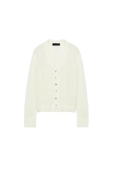 Front view of a raw knit cardigan with a V-neck, long sleeves, and front button fastening. Ribbed trims.