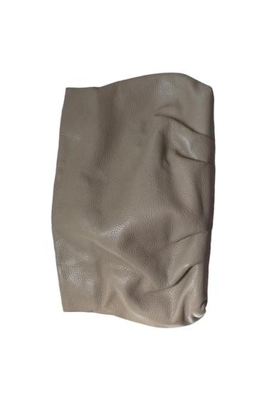 Close-up of a textured beige material with folds and a rough finish on a white background.