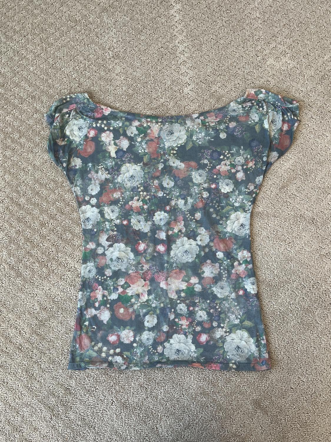 Front view of blouse with floral print in pastel tones.