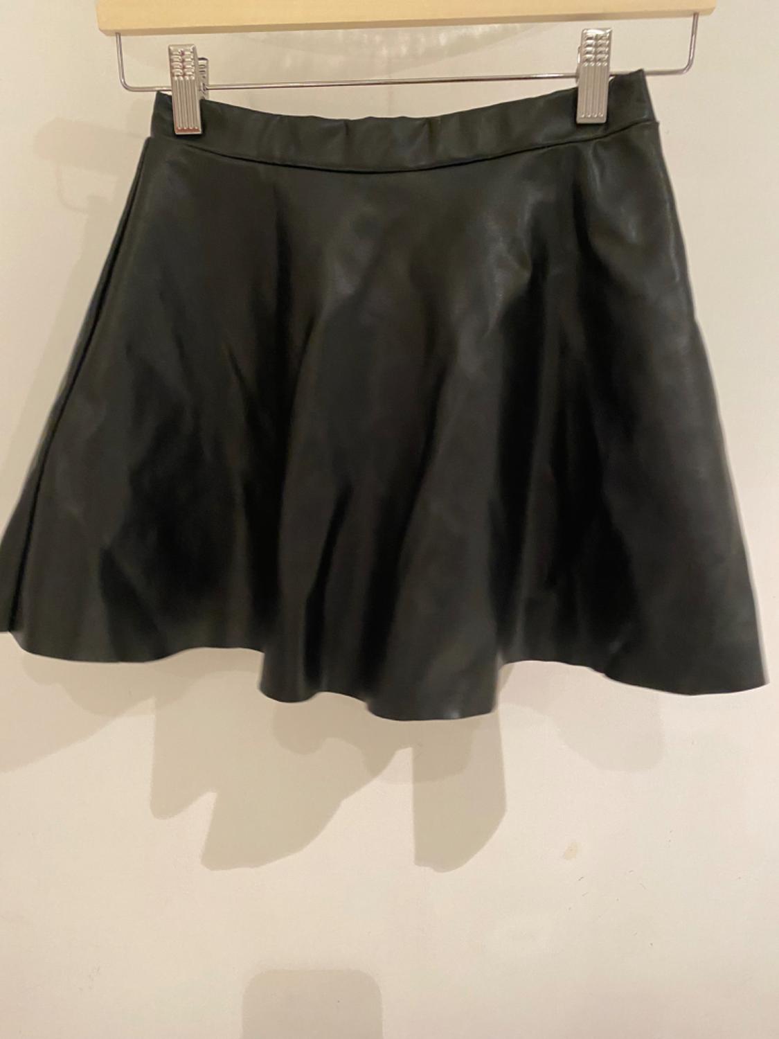 Front view of short black flared skirt, high waist.