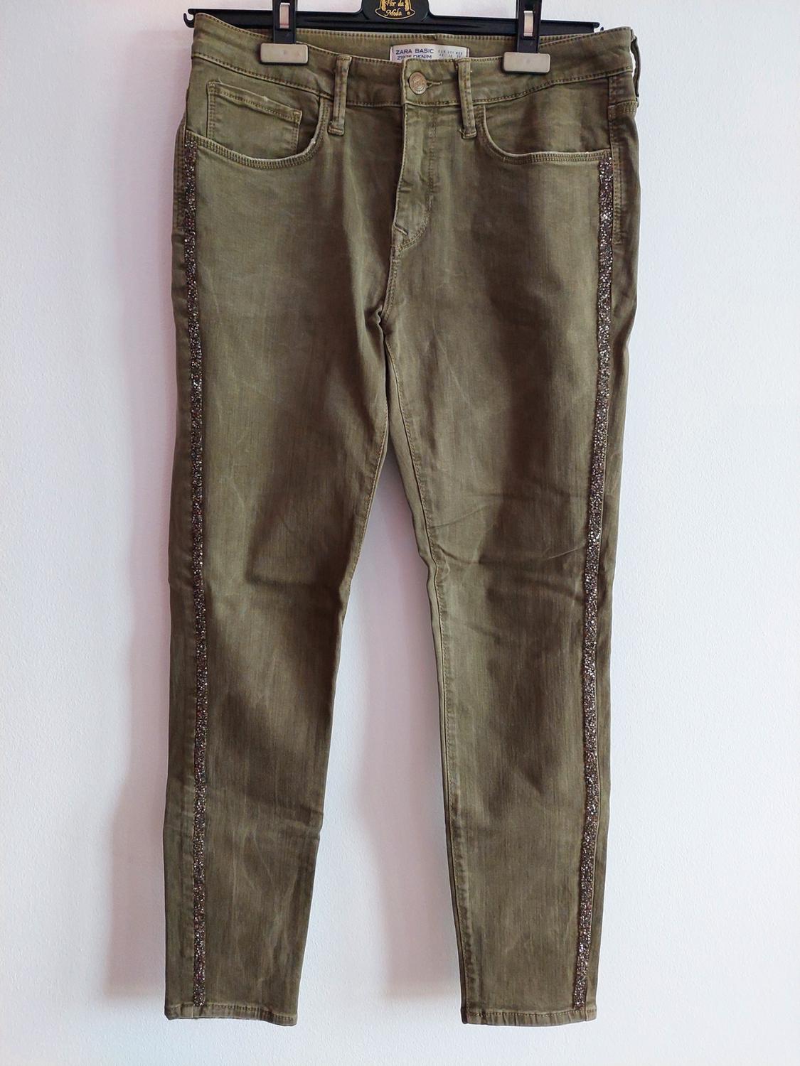 Olive green jeans on a hanger with a shiny side stripe. Text: Fashion Flower ZARA BASIC Z1975 DENIM.