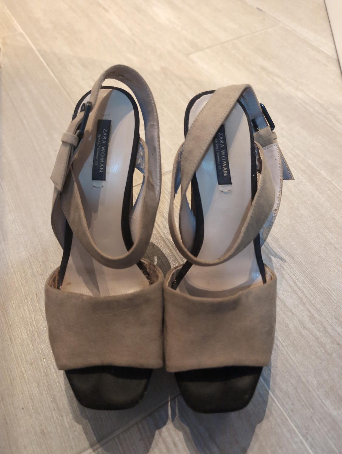 Pair of beige sandals with a black platform on a light-coloured floor. Visible text on the insole: ZARA WOMAN Spring / Summer 13.