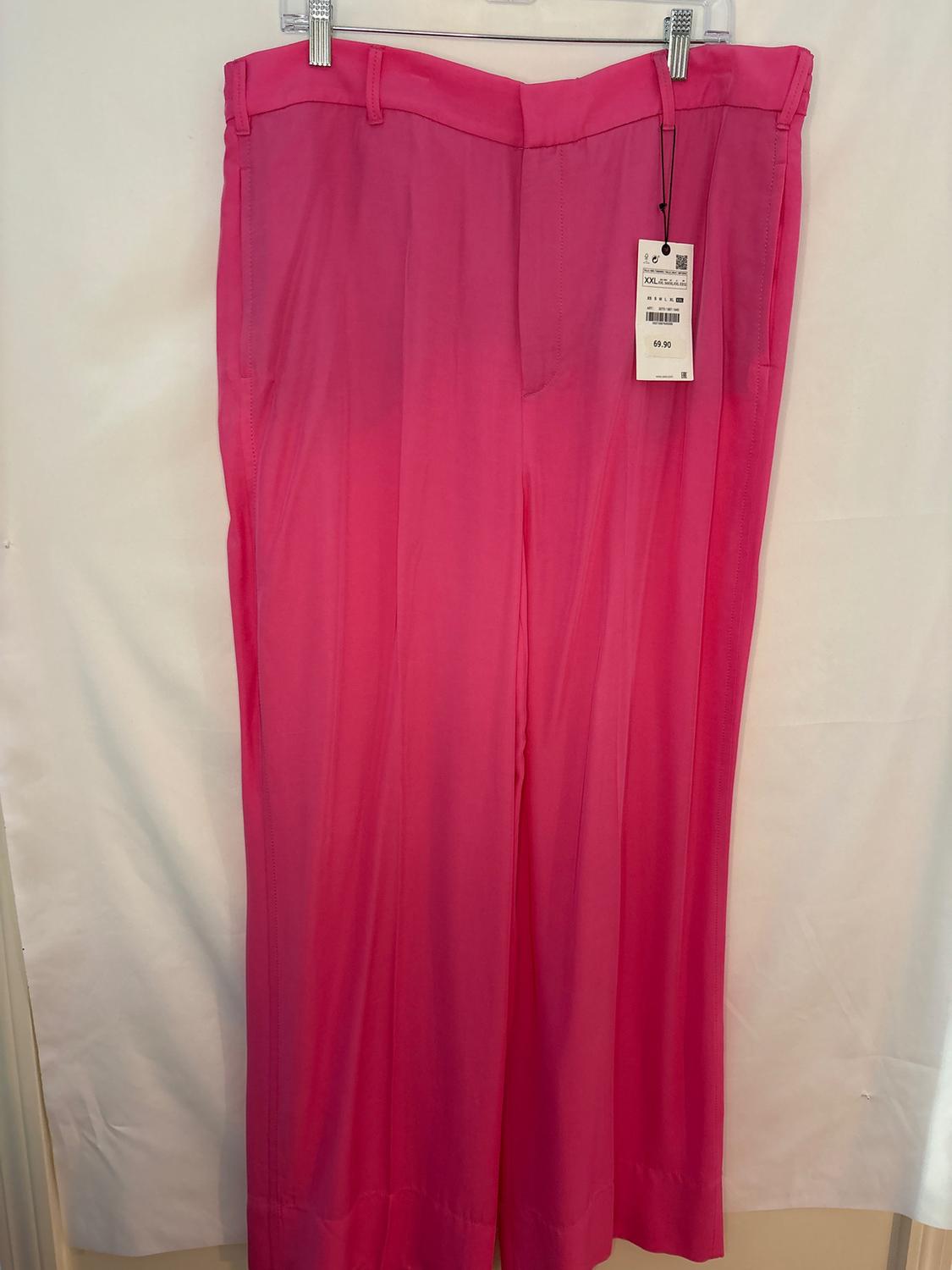 Hot pink wide-leg pants hanging on a hanger, with a visible price tag of 69.90. White background.
