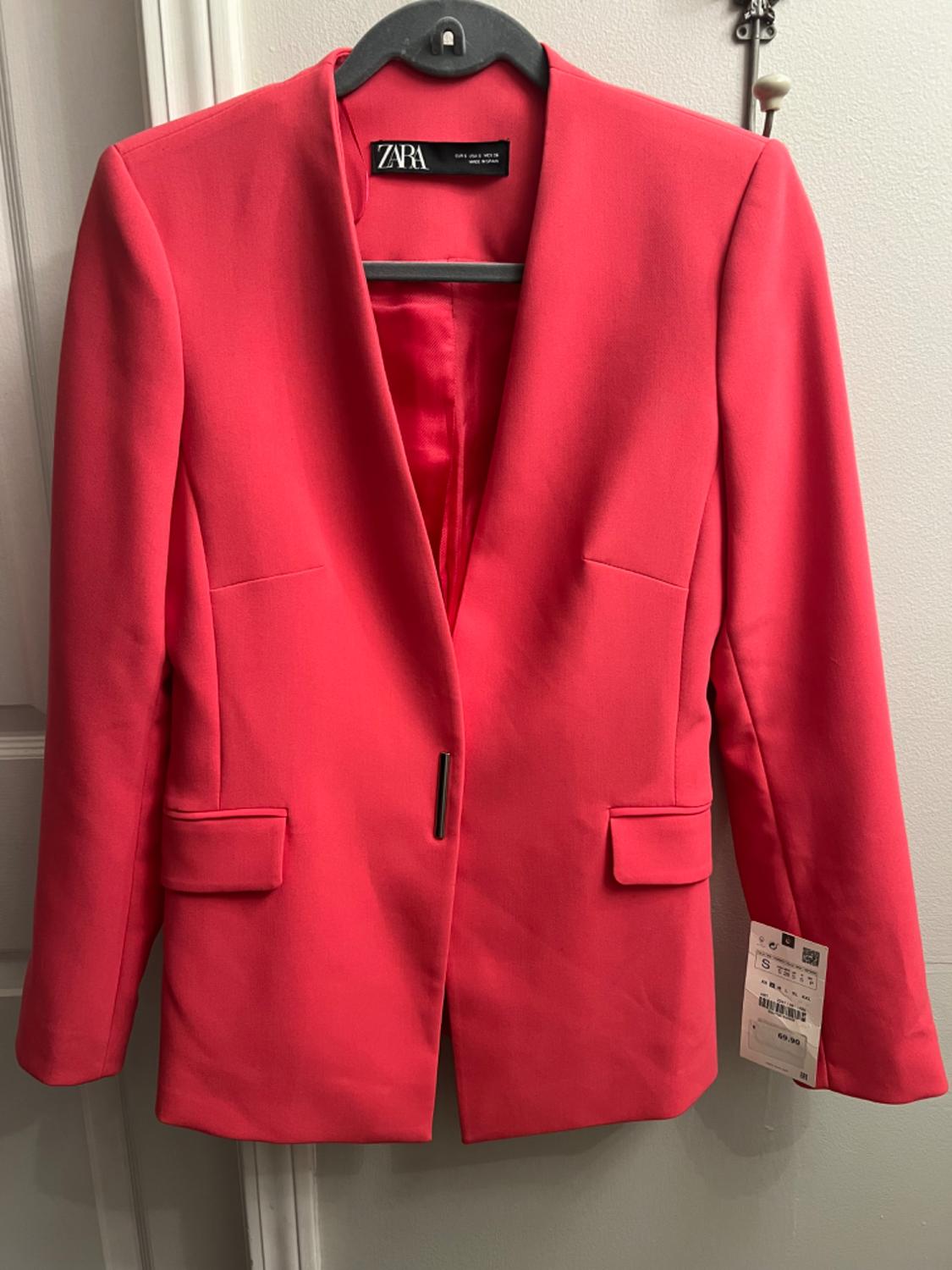 Front view of a red blazer with flap pockets and a button closure.
