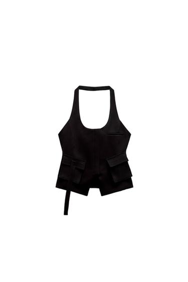 Black vest with a halter neck and large front pockets, on a white background. Modern and minimalist design.