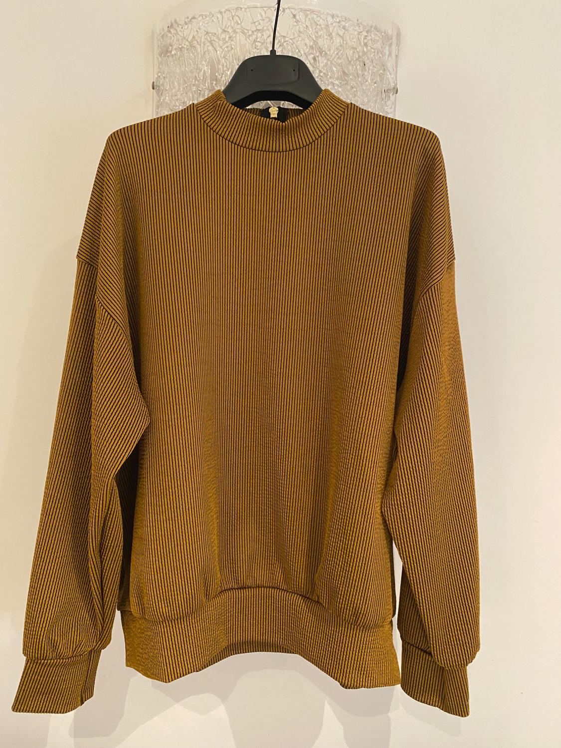 Brown jumper with thin vertical stripes, hanging on a black hanger against a white background. Long sleeves and a round neck.
