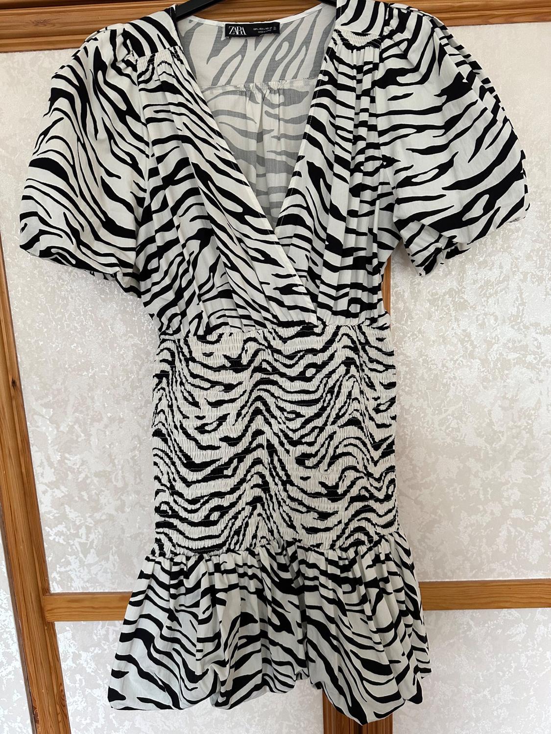 Front view of short dress with zebra print and puff sleeves.