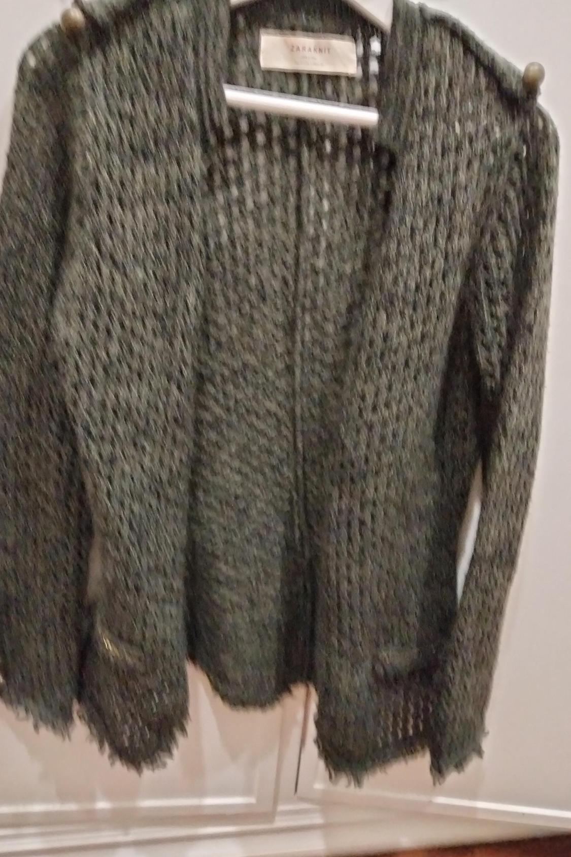 Front view of an open-knit cardigan with front pockets.