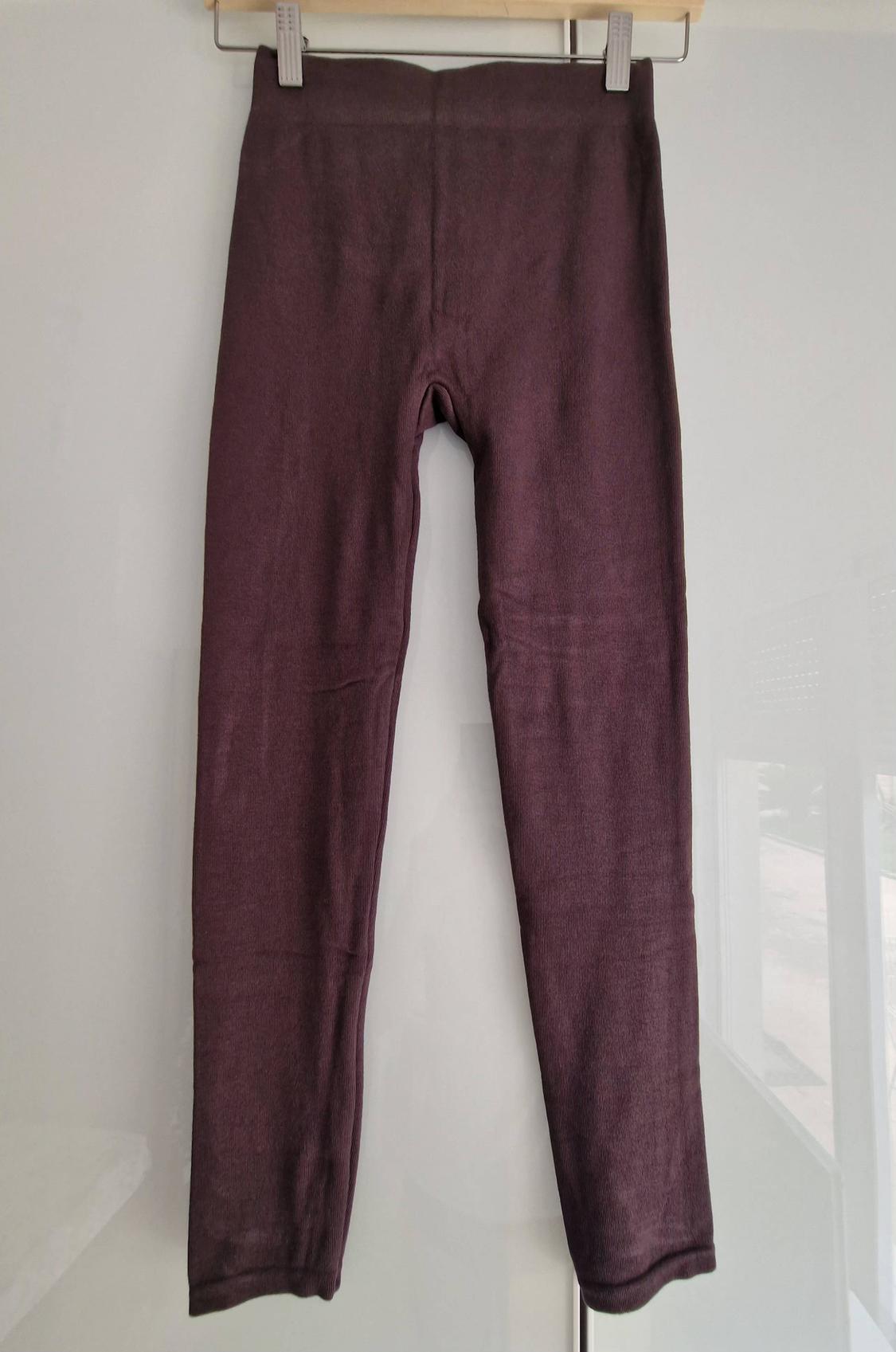 Dark maroon basic leggings hanging on a metal clip hanger against a white background.