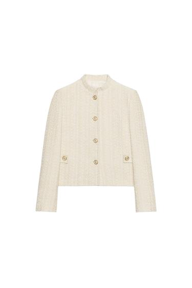 Front view of a raw-edge blazer with a raised collar, long sleeves, shoulder pads, flap pockets, and gold buttons.