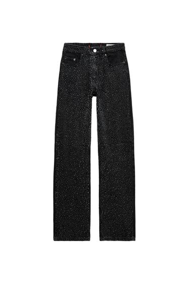 Black, straight-cut trousers with shimmering white polka dot details, front pockets, and a metallic button at the waist.