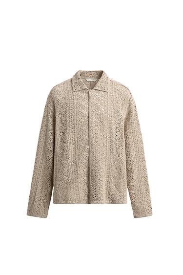 Front view of a sand-coloured overshirt with a crochet structure, notched lapel and button-up front fastening.