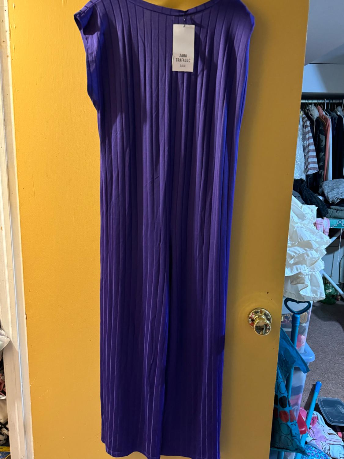 Front view of a purple sleeveless dress with a 'Zara Trafaluc' label, vertical pleats.