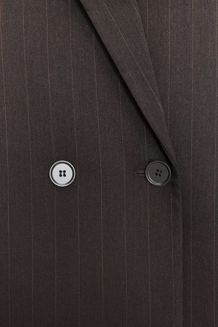 Podrobnosti o dvorednem zapenjanju na rjavem blazerju s tankimi črtami in reverjem.