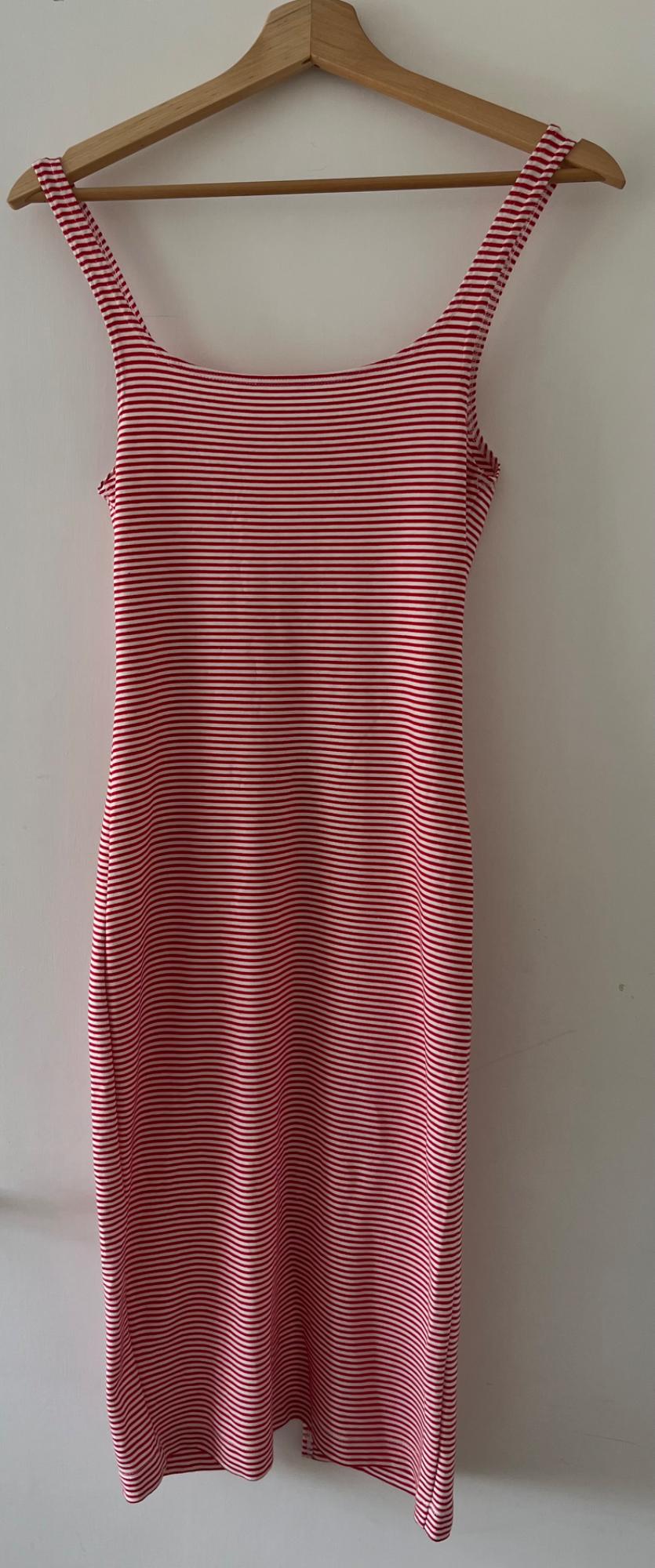 Fitted strappy dress with red and white horizontal stripes, hanging on a wooden hanger against a plain white wall.