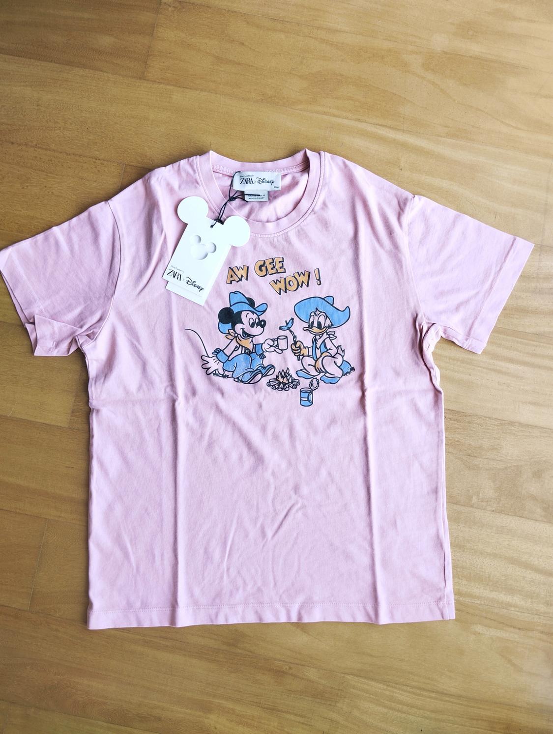 Pink T-shirt with animated character print and "AW GEE WOW!" text. Mouse-shaped label with Disney logo.