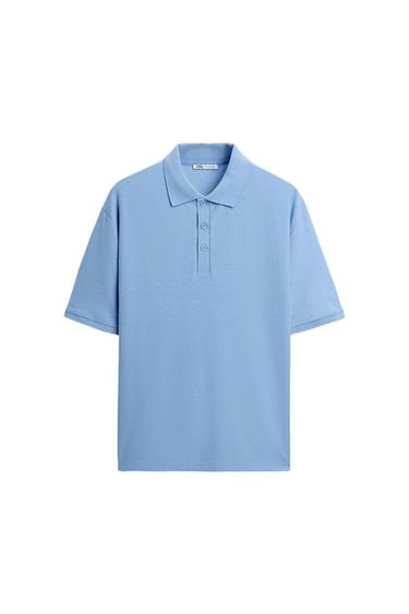Light blue, short-sleeved polo shirt with a classic collar and three buttons at the front. White background. Visible label inside the collar.