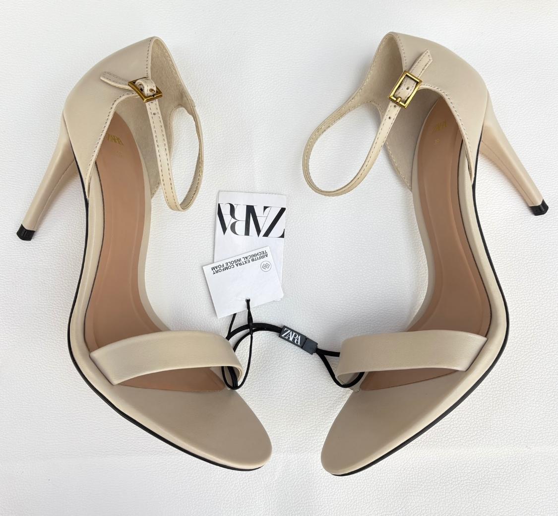 Pair of beige heeled sandals with ankle strap on a white background. Text: ZARA AIRFIT EXTRA COMFORT TECHNICAL INSOLE FOAM.