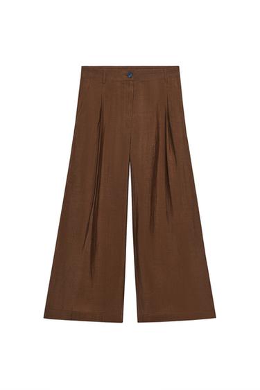 Front view of brown trousers with a wide-leg design, front pleats, and button fastening at the waist.