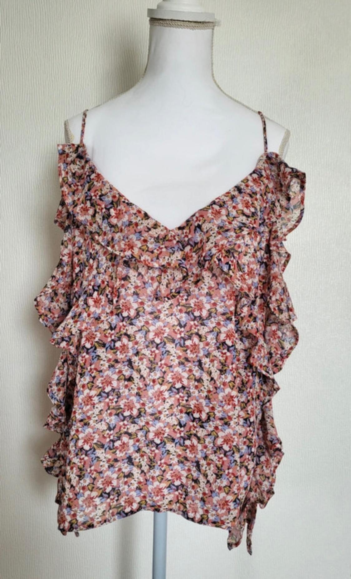 Pink floral print camisole with a V-neck and ruffles, displayed on a white mannequin against a light background.
